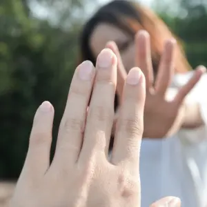 Frau, die mit ihrer eigenen Hand sich berühren will